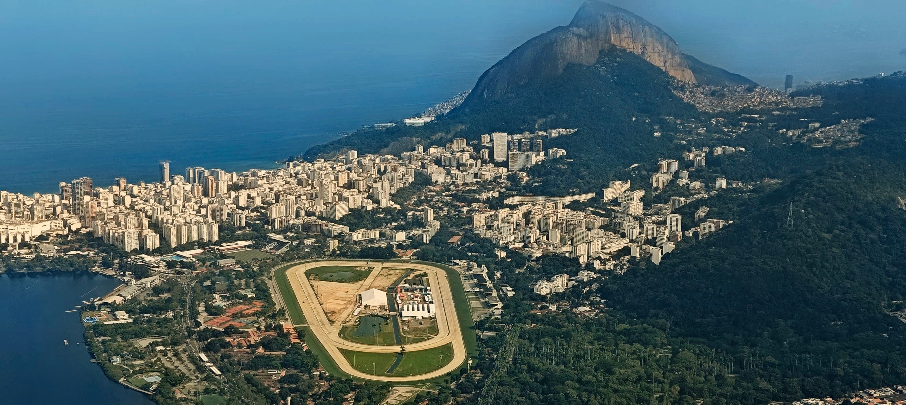 Hipódromo da Gávea racetrack, dense Rio neighbourhoods and a steep mountain ridge beyond.
