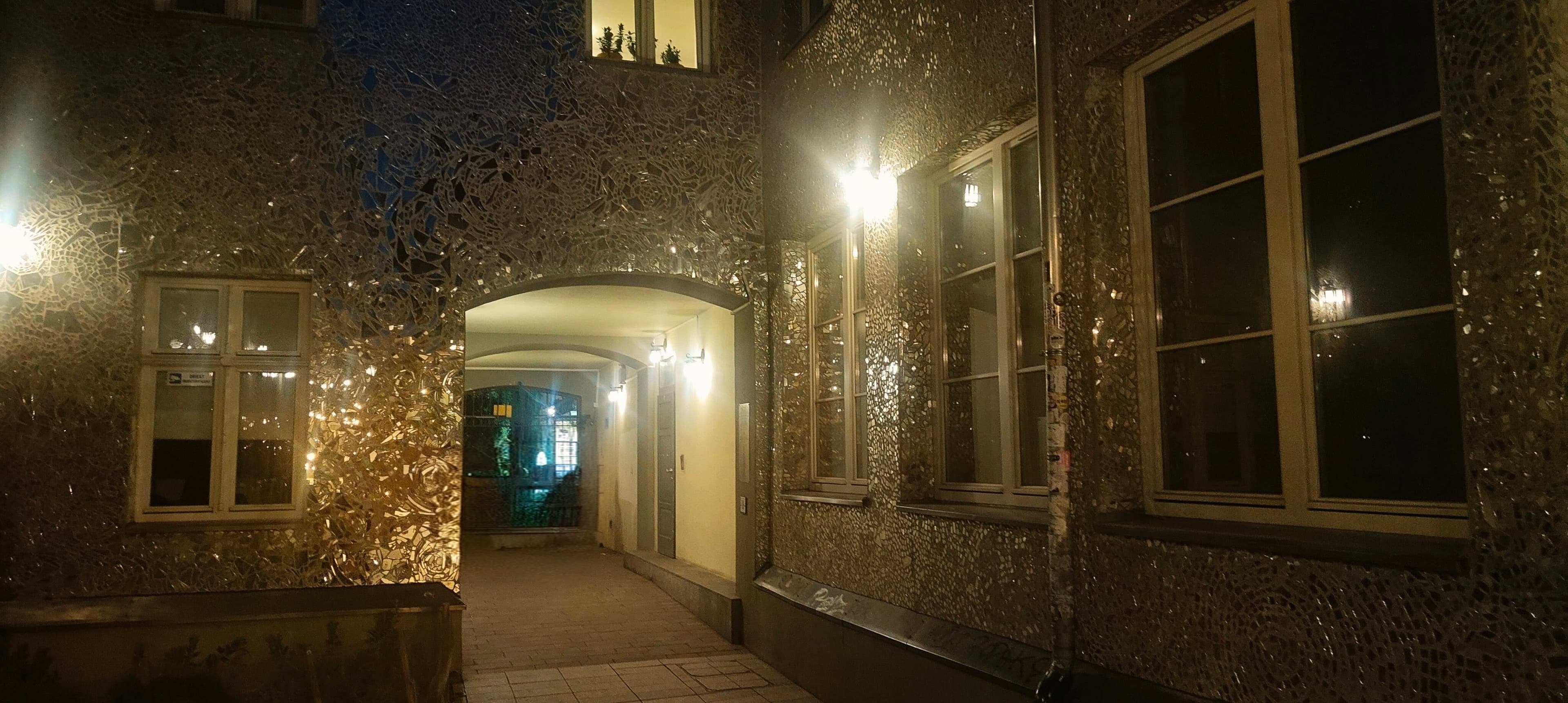 Narrow mirrored entrance passage inside Pasaż Róży in Łódź at night.