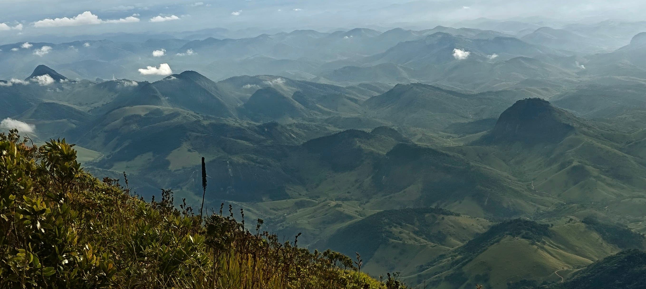 Layered green mountain ridges stretching into the distance under a cloudy sky.