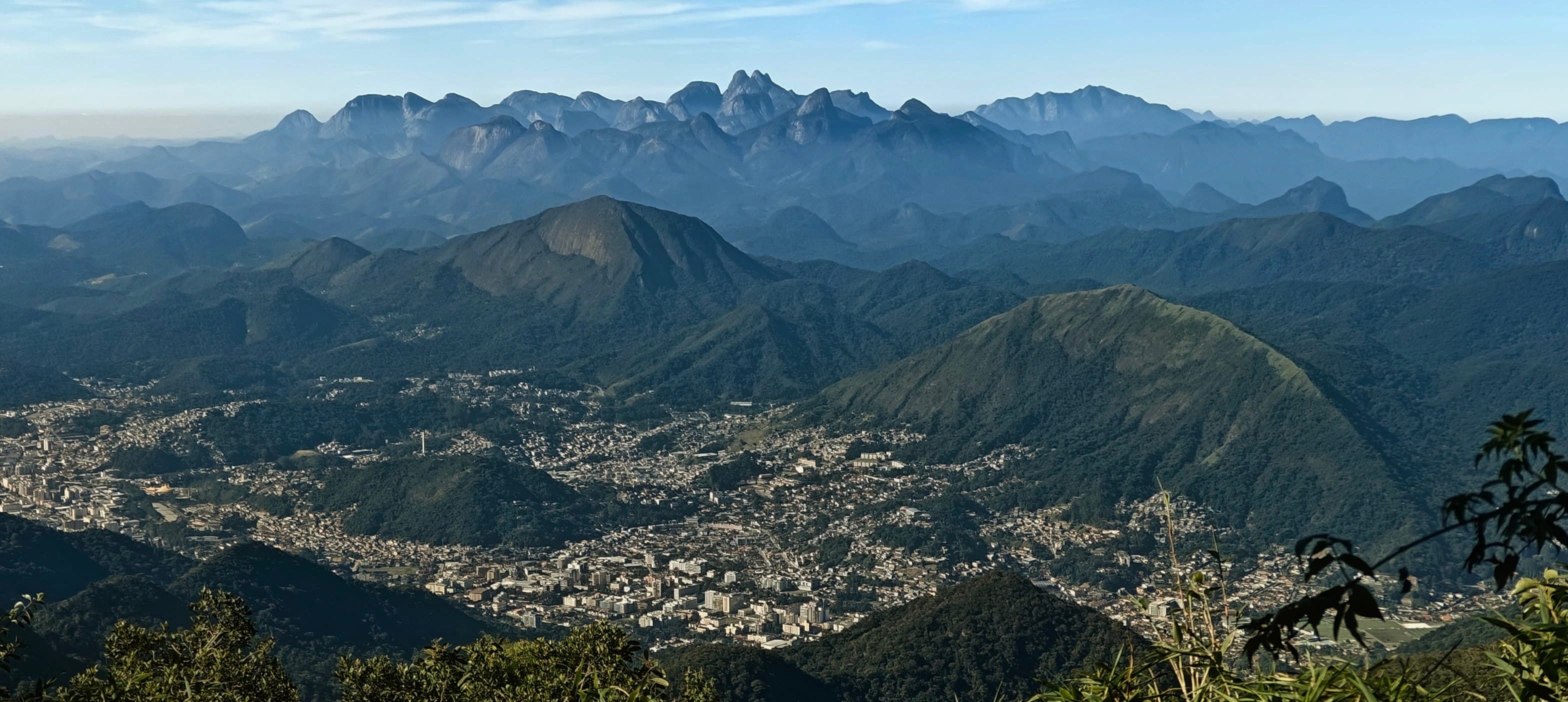 Teresópolis spread across a valley below layered mountains and a serrated skyline.
