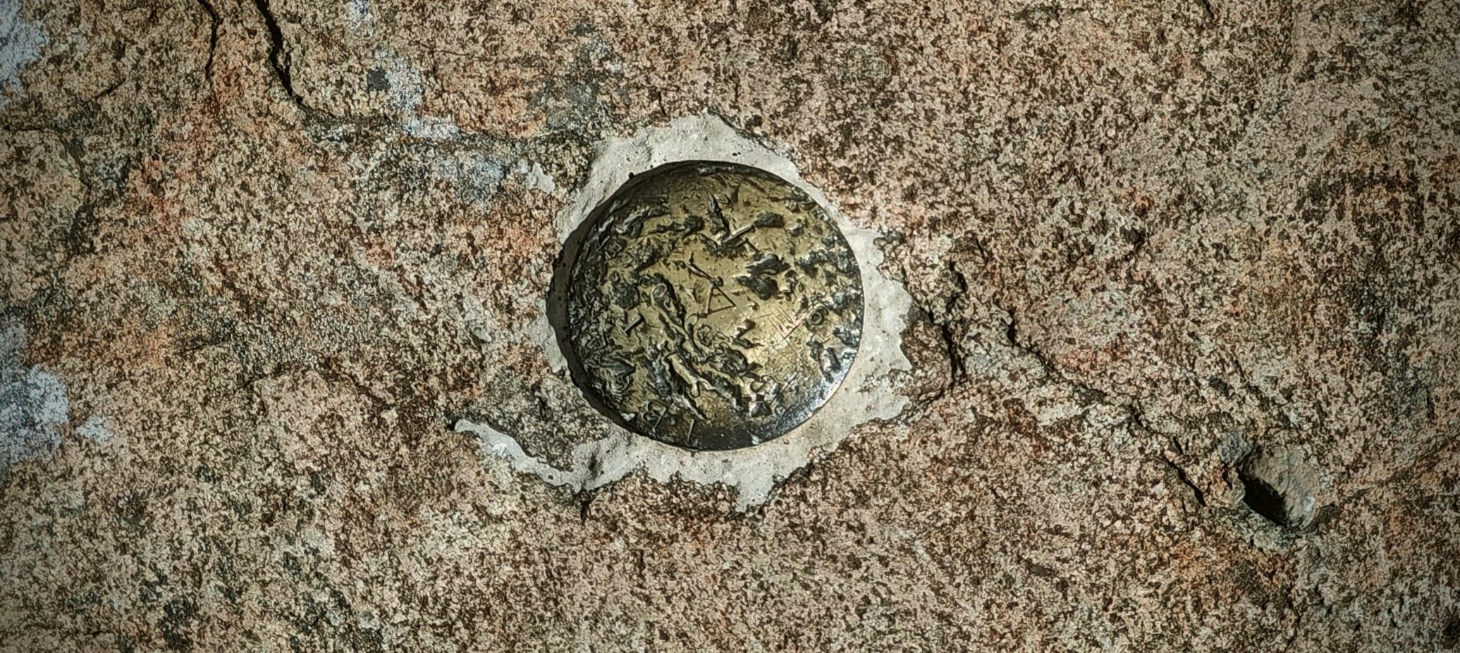 Circular survey marker set into the exposed summit rock of Pico da Bandeira.
