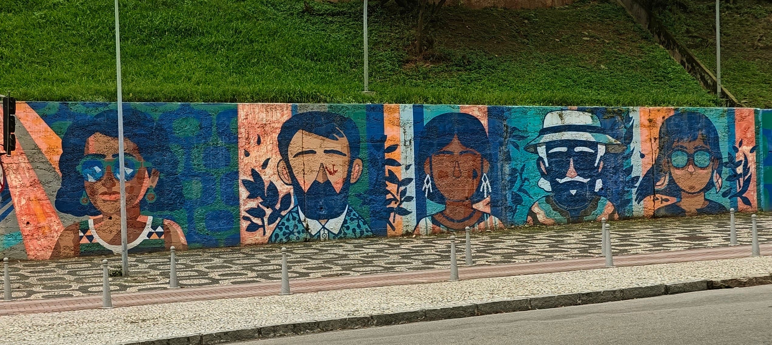 A long wall in central Rio is painted with a sequence of stylized faces and figures.