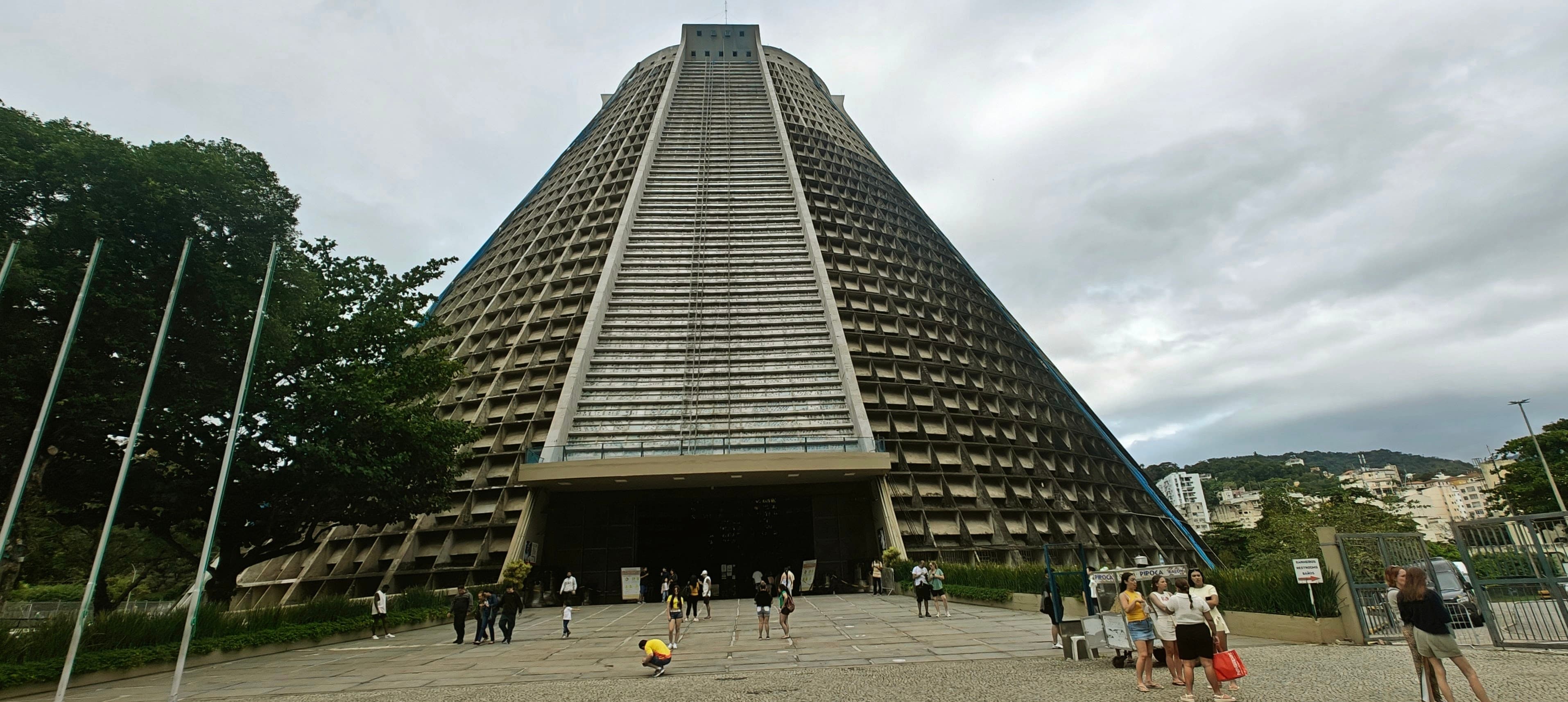 The broad conical Metropolitan Cathedral of Rio de Janeiro stands beneath an overcast sky.