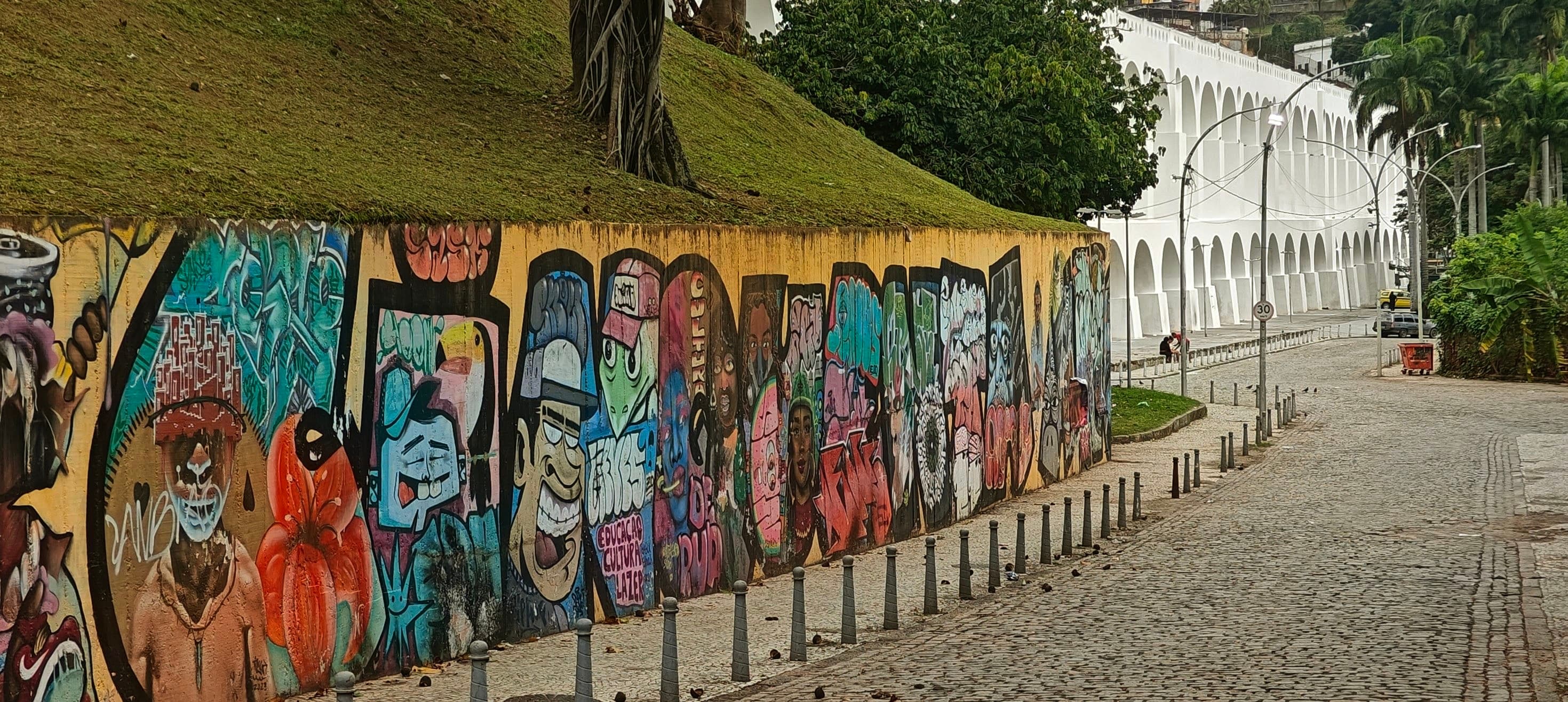 A long painted wall runs beside the white arches of the Arcos da Lapa aqueduct.