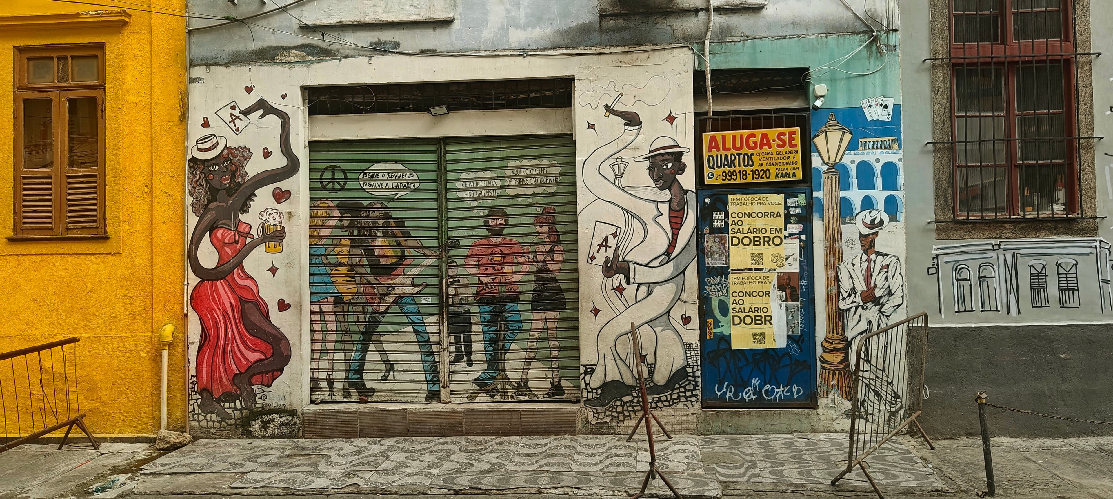 A weathered doorway and wall in Lapa are covered with layered street art and posters.