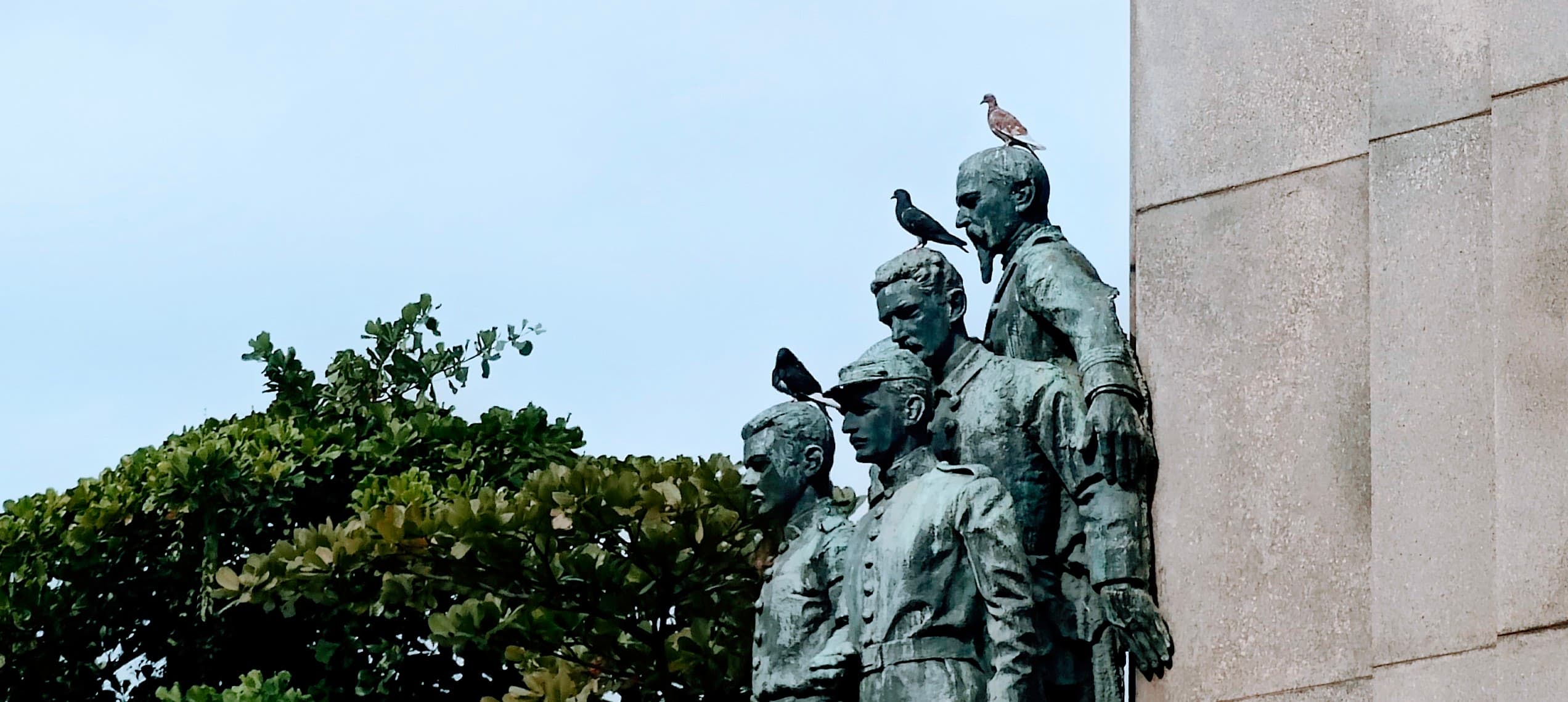 Bronze figures on the Monument to Marshal Deodoro da Fonseca, with pigeons perched on them.