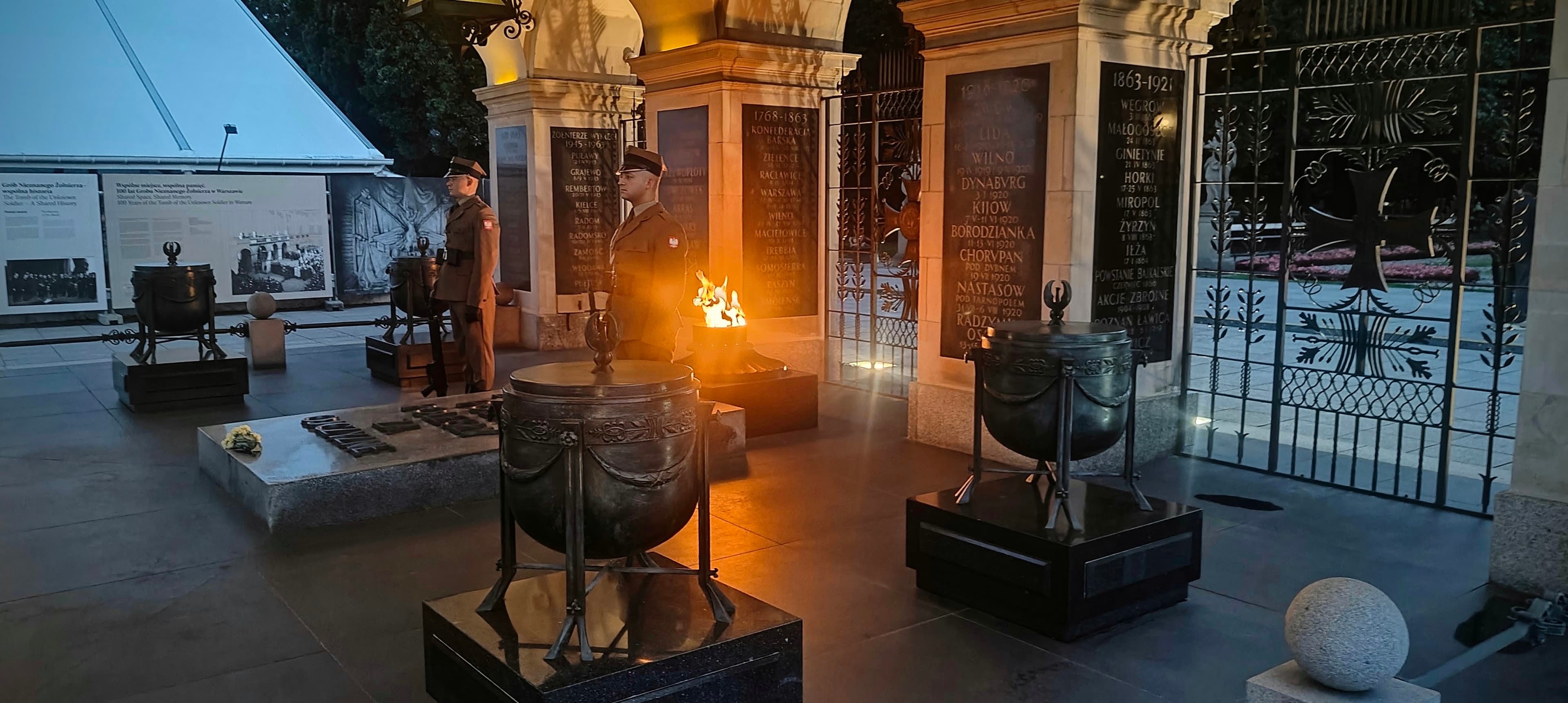 Eternal flame and honour guard at the Tomb of the Unknown Soldier in Warsaw at dusk.