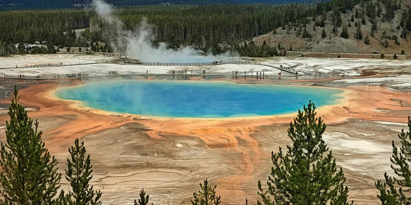 Grand Prismatic Spring seen from above, with a turquoise centre surrounded by orange microbial mats.