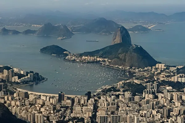 Sugarloaf Mountain above Guanabara Bay, with Rio neighbourhoods spread across the foreground.