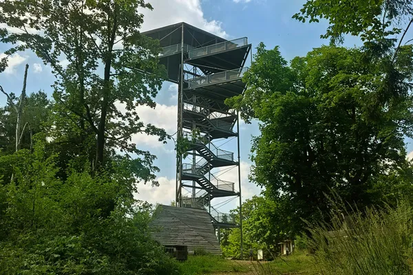 Modern steel observation tower rising above trees on the summit of Trójgarb.