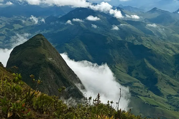 Green mountain ridges and low clouds seen from high on Pedra do Desengano.